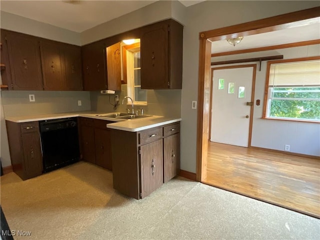 kitchen with a sink, baseboards, black dishwasher, light countertops, and dark brown cabinets