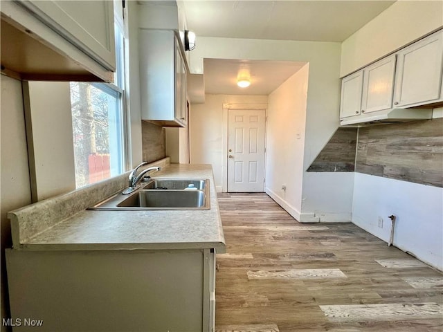 kitchen featuring light hardwood / wood-style floors, sink, and white cabinets