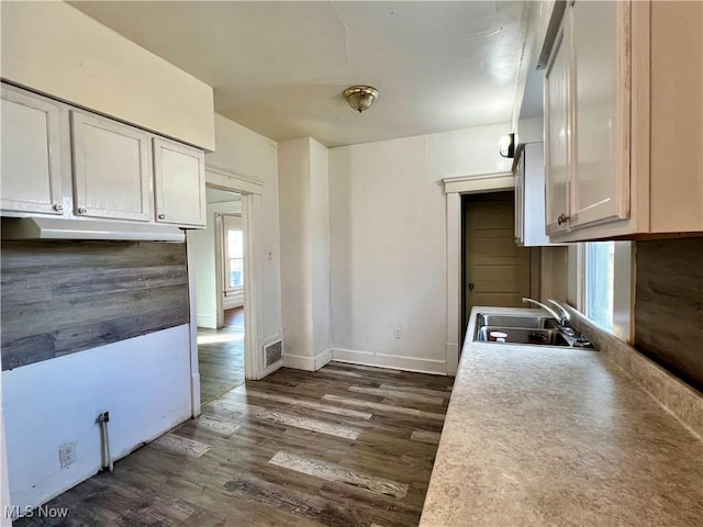 kitchen with sink, dark wood-type flooring, and white cabinets