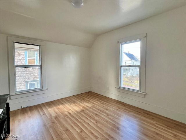 bonus room with lofted ceiling and light wood-type flooring