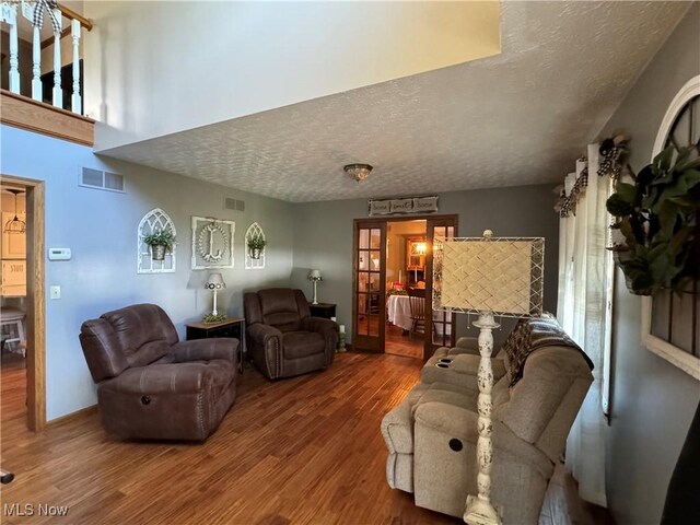 living room with a textured ceiling and wood-type flooring