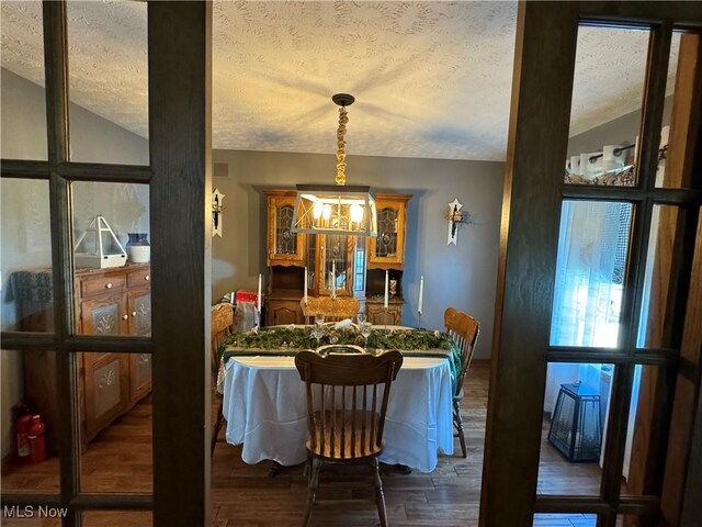 dining space with dark hardwood / wood-style flooring and a textured ceiling