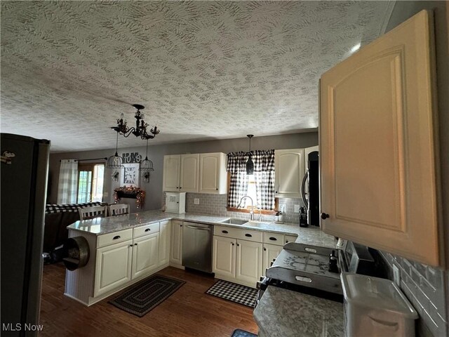 kitchen with dishwasher, a wealth of natural light, decorative light fixtures, and dark hardwood / wood-style floors