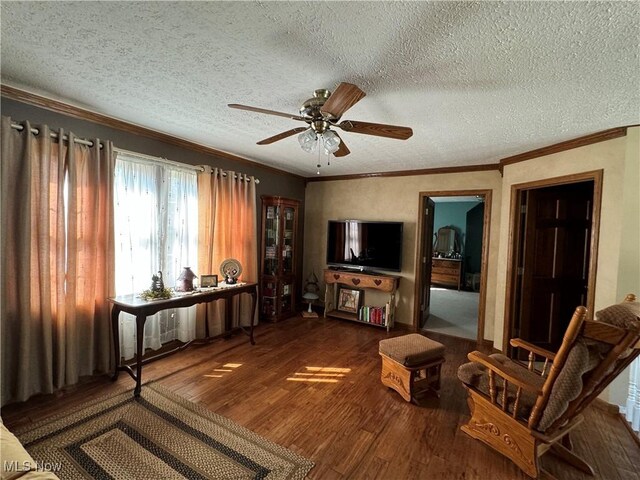 living room featuring ceiling fan, dark hardwood / wood-style floors, crown molding, and a textured ceiling