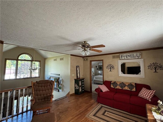 living room with ornamental molding, a textured ceiling, vaulted ceiling, ceiling fan, and dark wood-type flooring