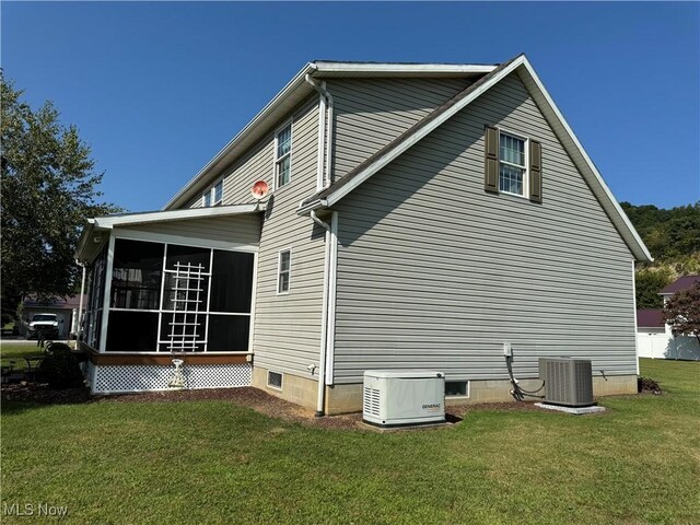 view of home's exterior featuring cooling unit, a lawn, and a sunroom