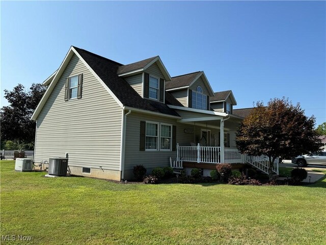 view of side of home with a yard, a porch, and cooling unit