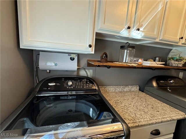 laundry area featuring washer / clothes dryer and cabinets