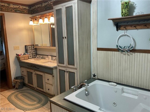 bathroom with tile patterned flooring, vanity, and a bath