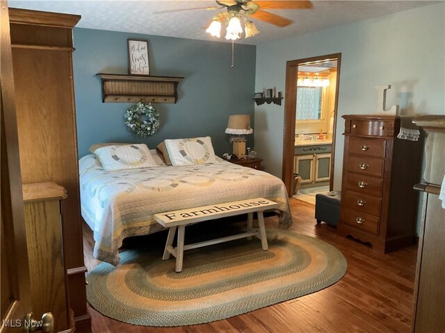 bedroom featuring a textured ceiling, ceiling fan, ensuite bathroom, and hardwood / wood-style flooring