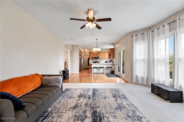 carpeted living room with ceiling fan