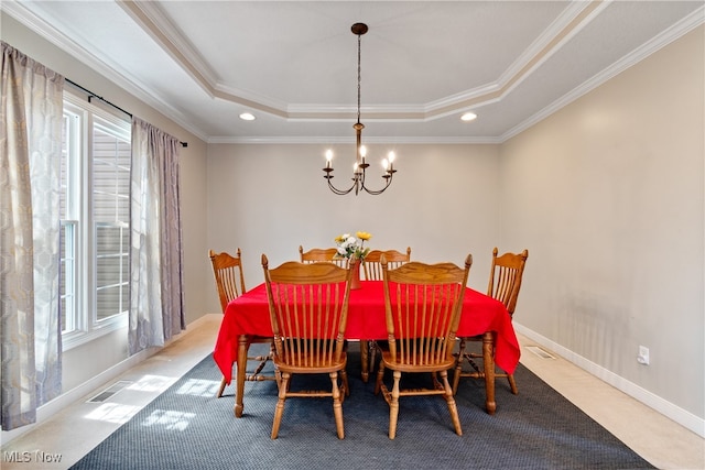 dining area featuring crown molding, an inviting chandelier, a tray ceiling, and carpet floors