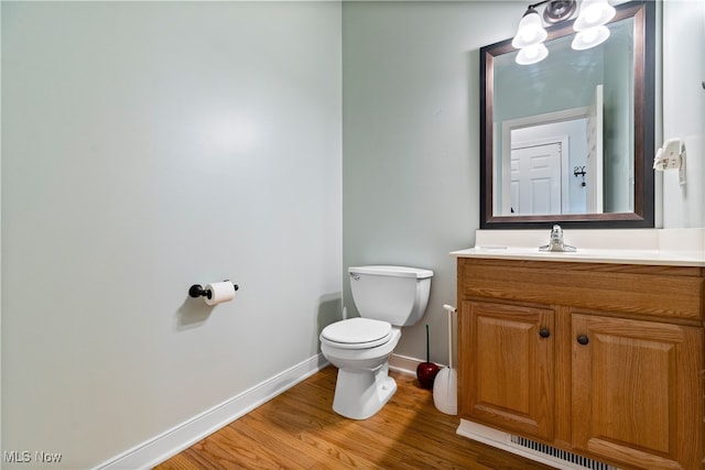 bathroom featuring toilet, hardwood / wood-style floors, and vanity