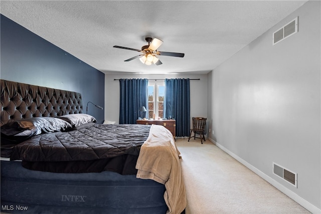 carpeted bedroom with ceiling fan and a textured ceiling