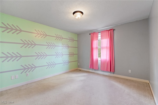 carpeted spare room featuring a textured ceiling