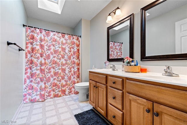 bathroom with a skylight, vanity, tile patterned floors, toilet, and a shower with curtain