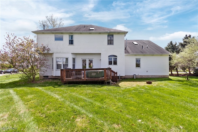 back of property with a deck and a lawn