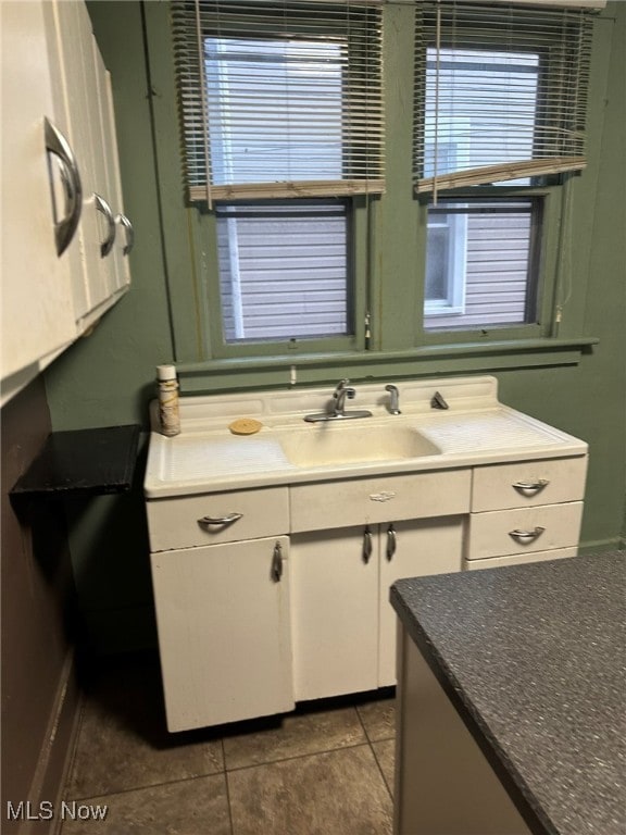 kitchen featuring sink, tile patterned floors, and white cabinets