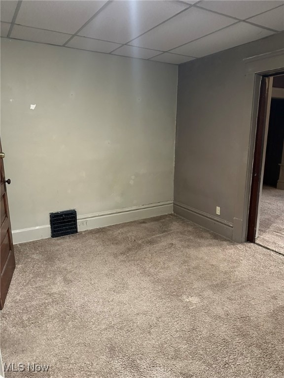 spare room featuring carpet and a paneled ceiling