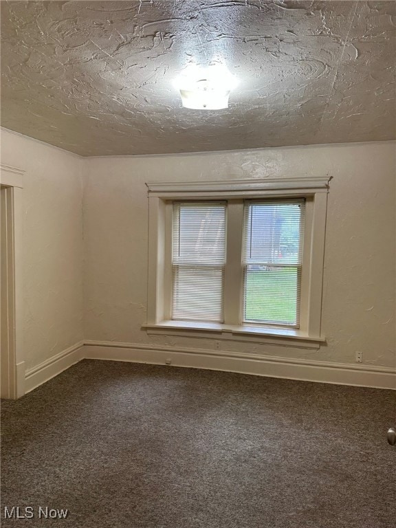 carpeted spare room with a textured ceiling