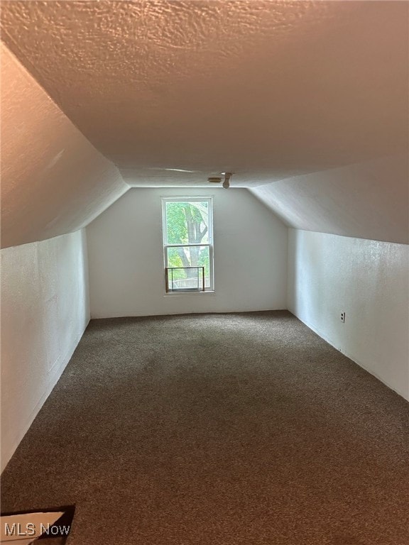 bonus room with a textured ceiling, carpet floors, and vaulted ceiling