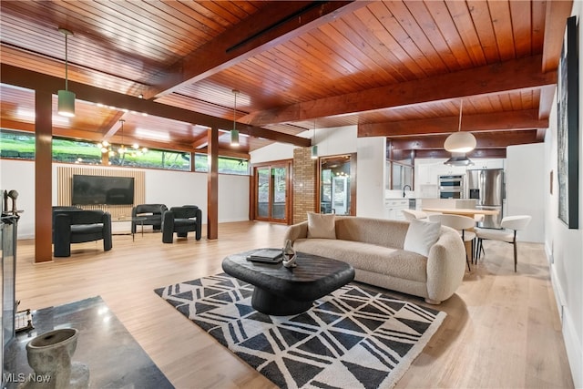 living room featuring sink, light wood-type flooring, beamed ceiling, and wooden ceiling