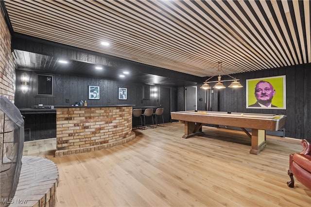 game room with billiards, light hardwood / wood-style floors, and wood walls