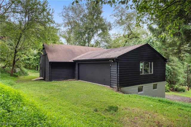 view of side of property with a garage and a lawn