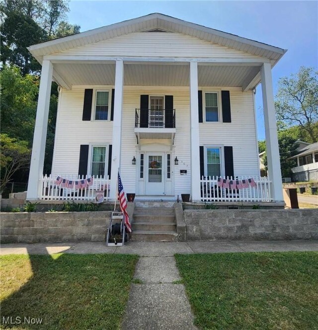 neoclassical / greek revival house featuring covered porch