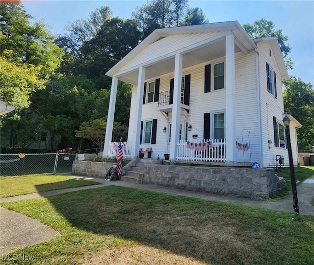 neoclassical / greek revival house with a balcony and a front yard