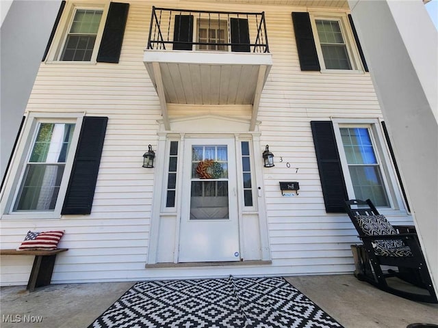 view of exterior entry featuring a balcony