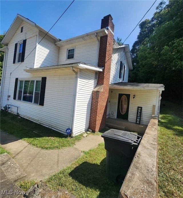 view of property exterior featuring a yard and a chimney