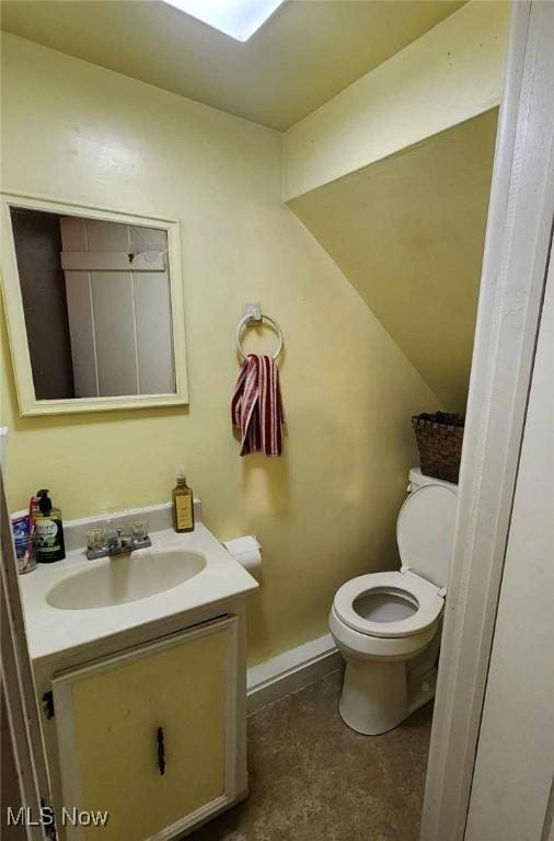 bathroom with toilet, baseboards, and vanity