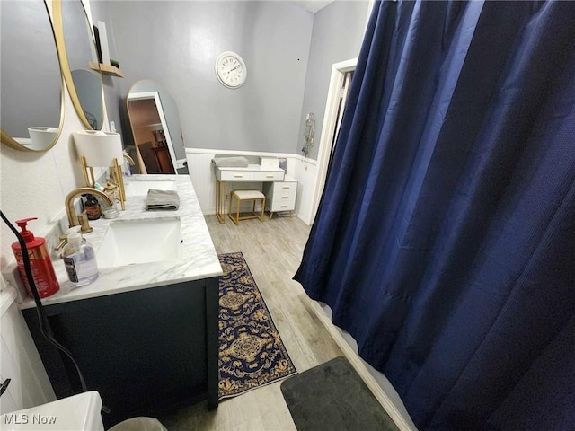 bathroom featuring double vanity, a sink, and wood finished floors