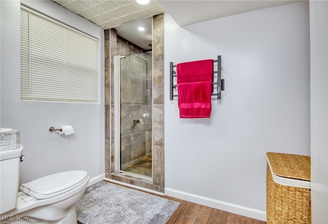 bathroom with hardwood / wood-style flooring, a shower with shower door, and toilet