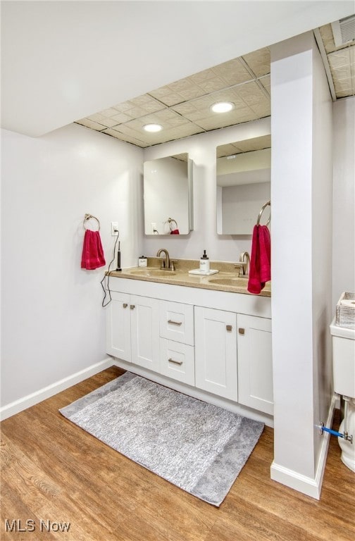 bathroom featuring hardwood / wood-style flooring, a paneled ceiling, and vanity