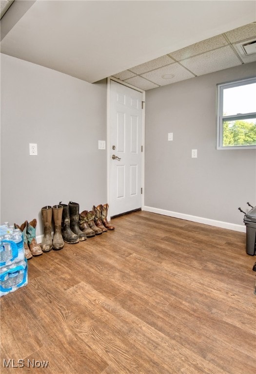 interior space featuring a drop ceiling and wood-type flooring