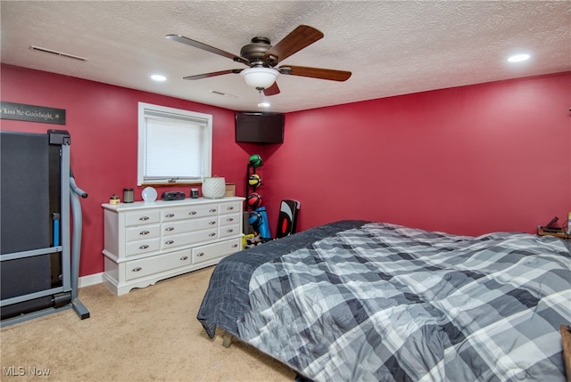 bedroom featuring ceiling fan, a textured ceiling, and light colored carpet