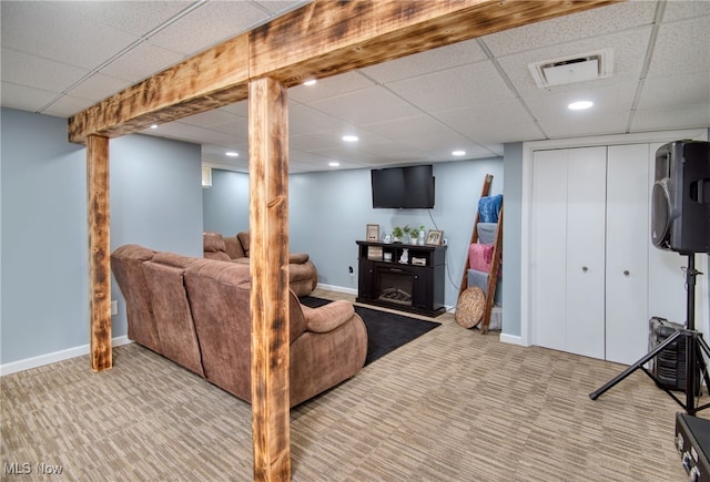 living room featuring a drop ceiling and light colored carpet