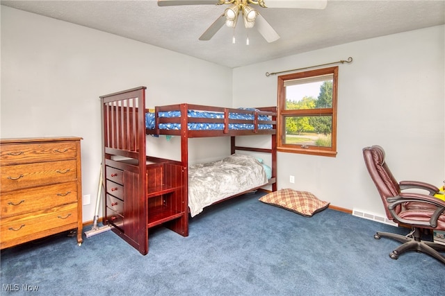 bedroom featuring ceiling fan, a textured ceiling, and carpet floors