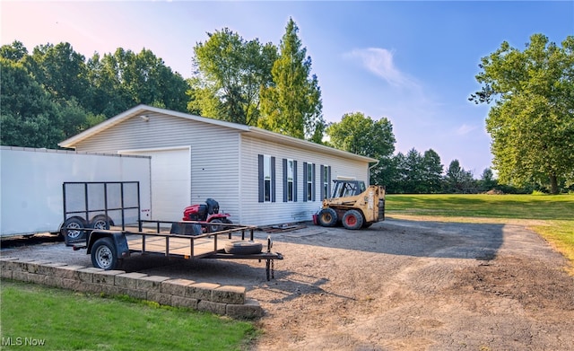 exterior space with a yard, a garage, and an outbuilding