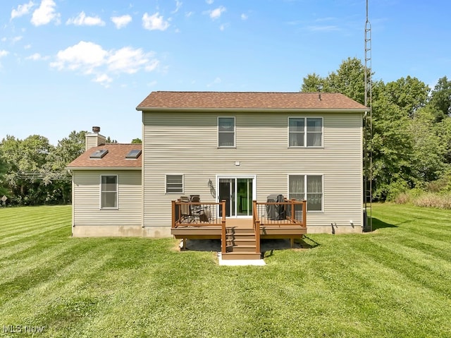 rear view of house featuring a yard and a deck