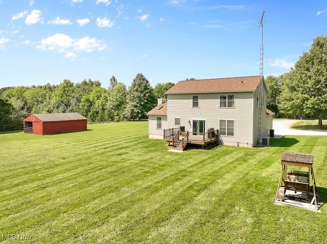 back of property with a wooden deck, a storage unit, and a yard