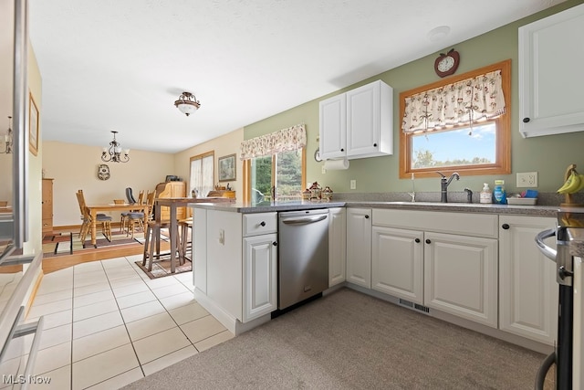 kitchen with appliances with stainless steel finishes, kitchen peninsula, white cabinets, and sink