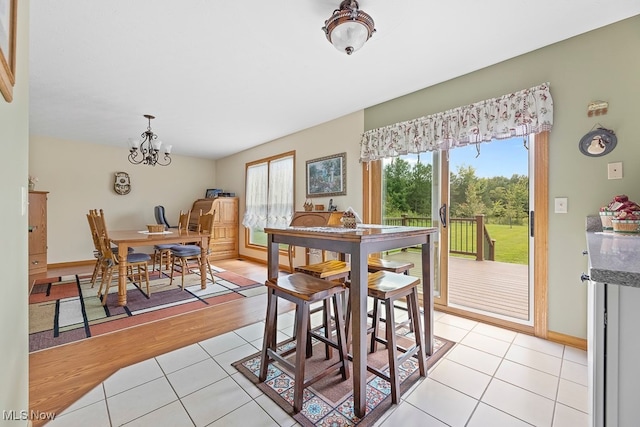 dining space featuring an inviting chandelier and light wood-type flooring