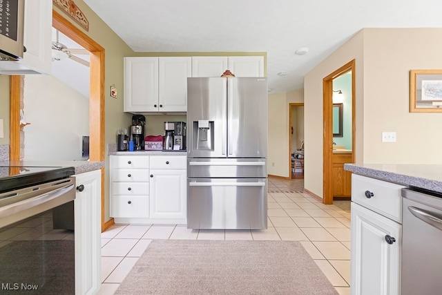 kitchen featuring white cabinetry, appliances with stainless steel finishes, and light tile patterned floors