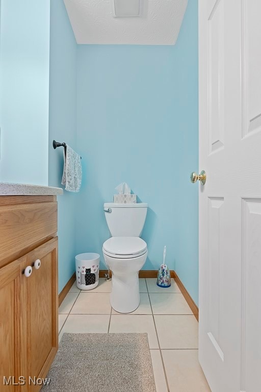 bathroom featuring vanity, a textured ceiling, toilet, and tile patterned floors