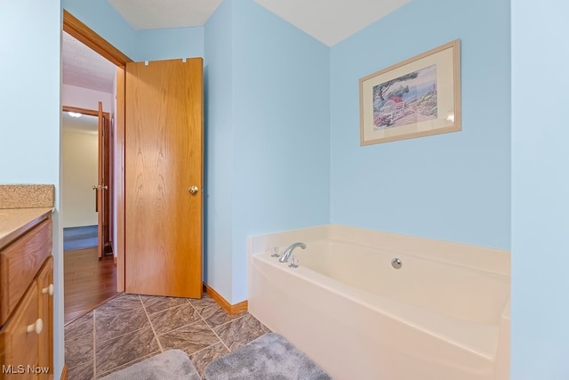 bathroom featuring vanity, a bathing tub, and a textured ceiling