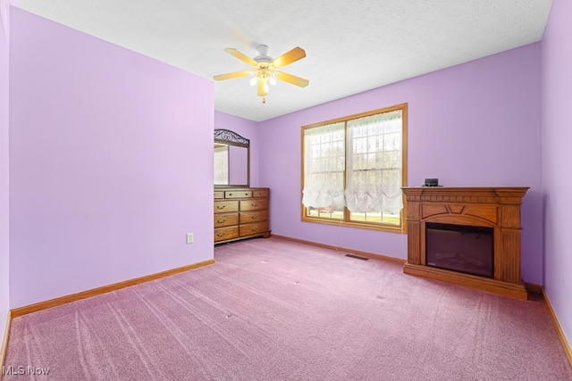 interior space featuring light carpet, a textured ceiling, and ceiling fan