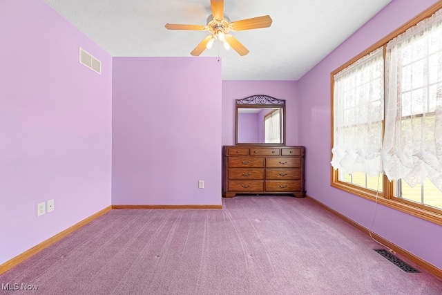 unfurnished bedroom with light carpet, multiple windows, and ceiling fan